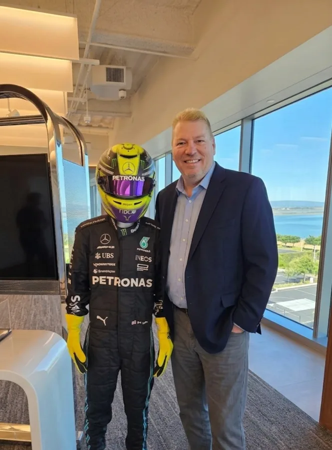Matt Cox beside a life-size statue of a Formula 1 driver in Petronas team gear